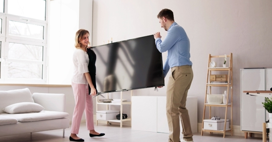 Homeowners moving a TV